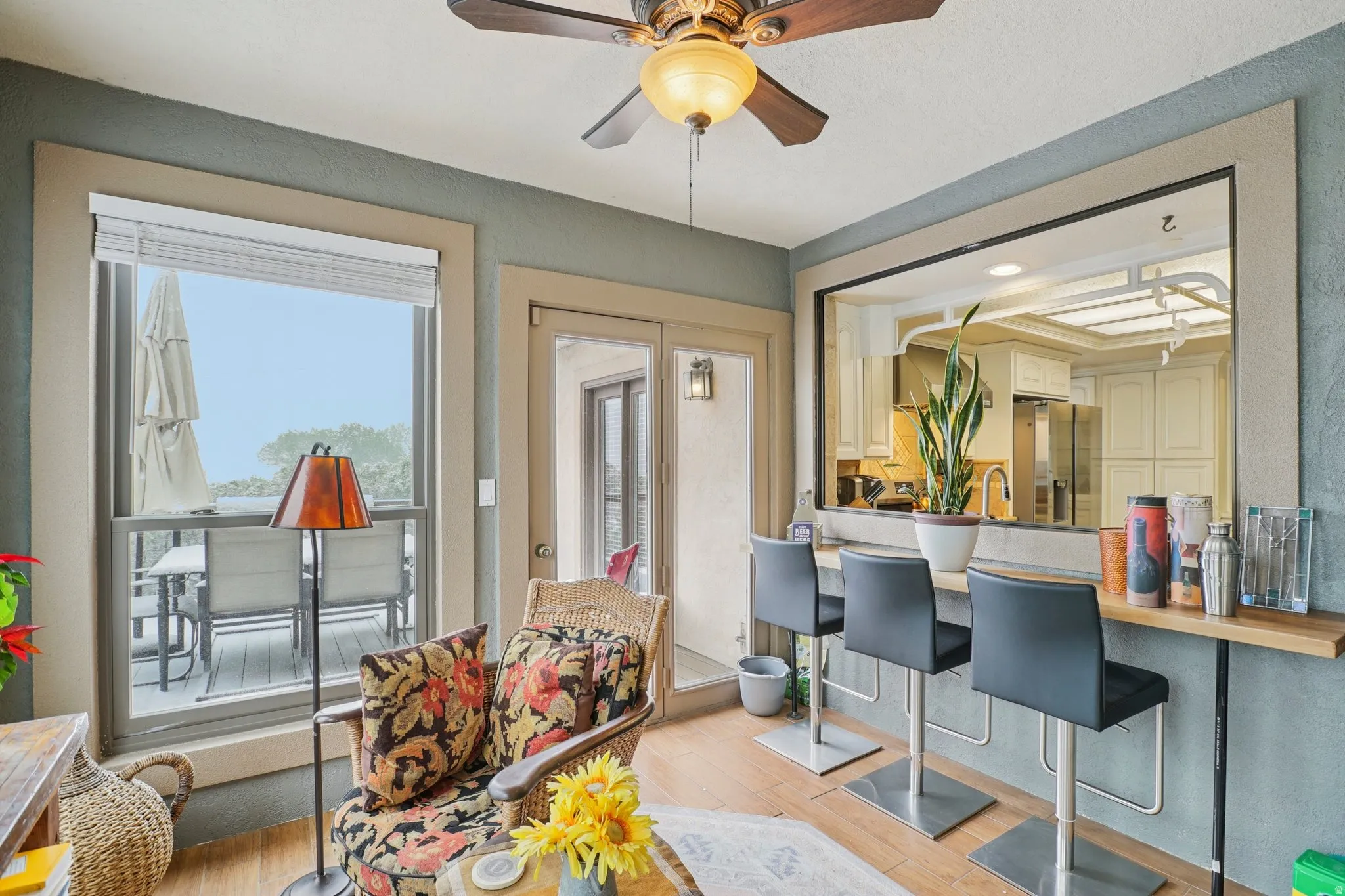 Living room featuring light wood finished floors, ceiling fan, and a textured wall