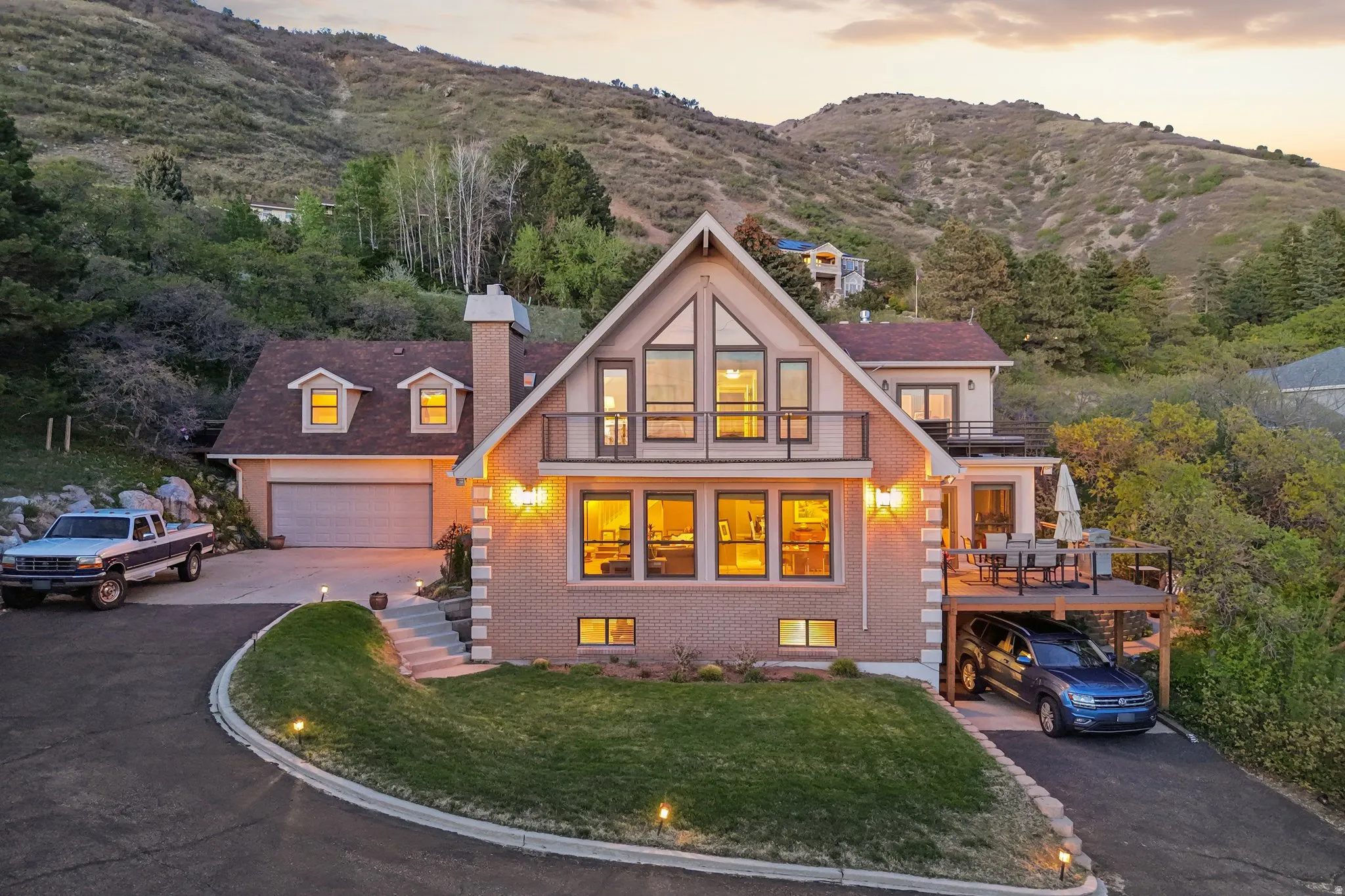 View of front of home with a chimney, brick siding, driveway, and a mountain view