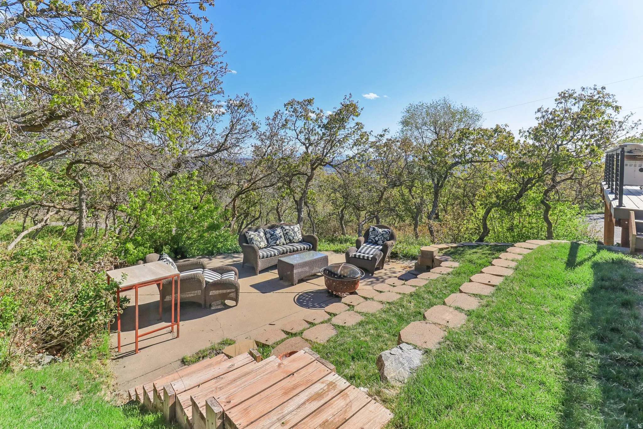 View of green lawn with a patio area and an outdoor living space with a fire pit
