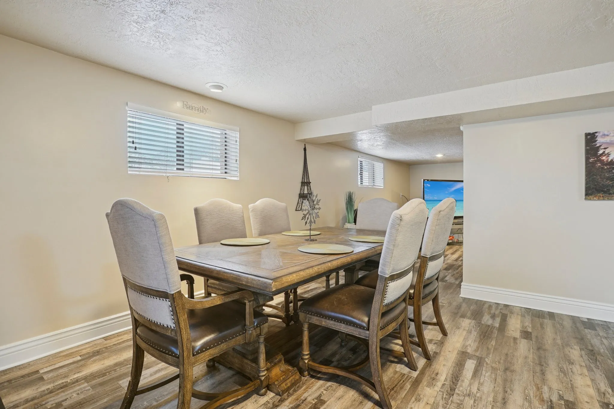 Dining area with a textured ceiling and light wood finished floors