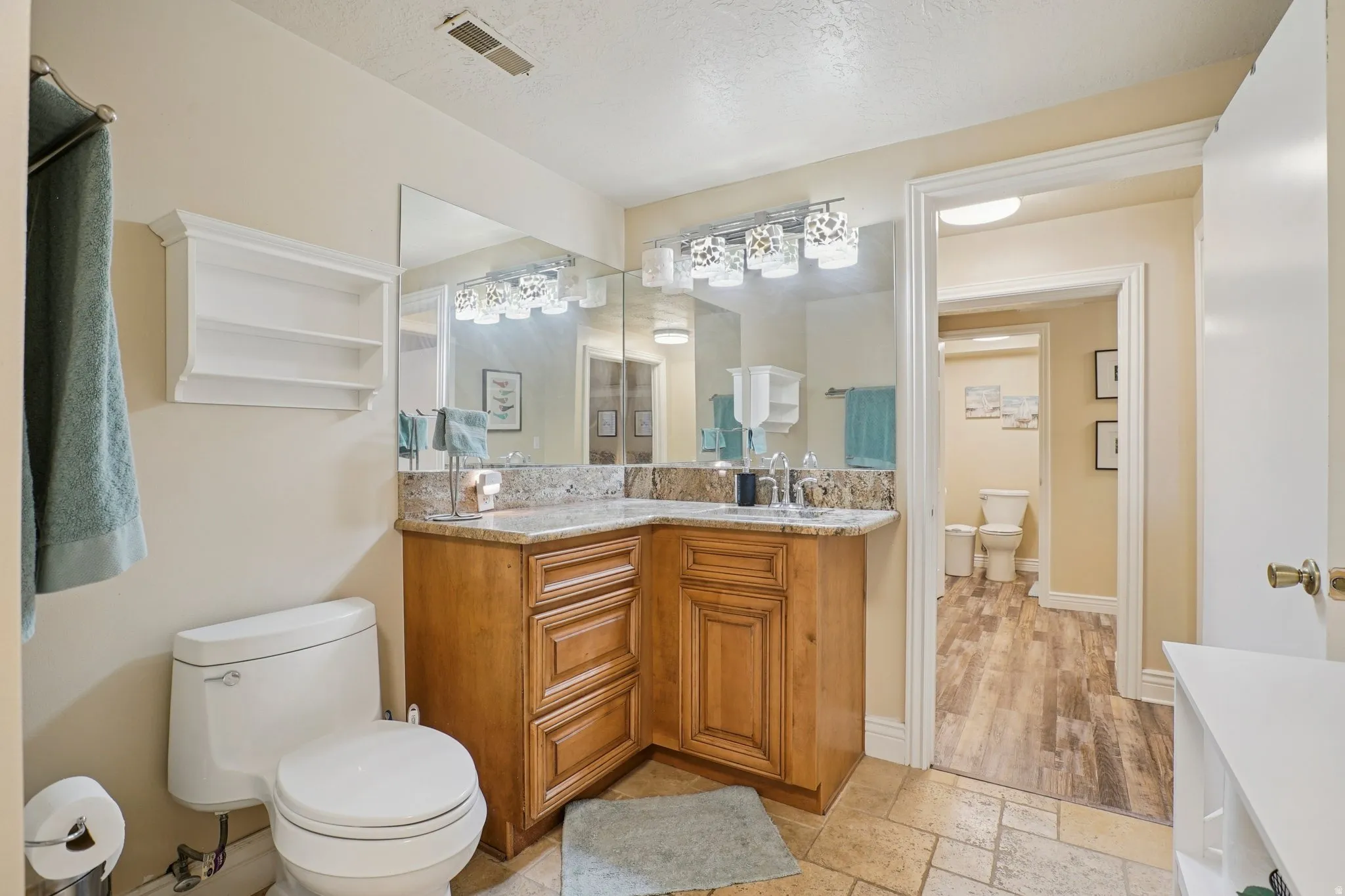 Bathroom with stone tile floors, vanity, and a textured ceiling