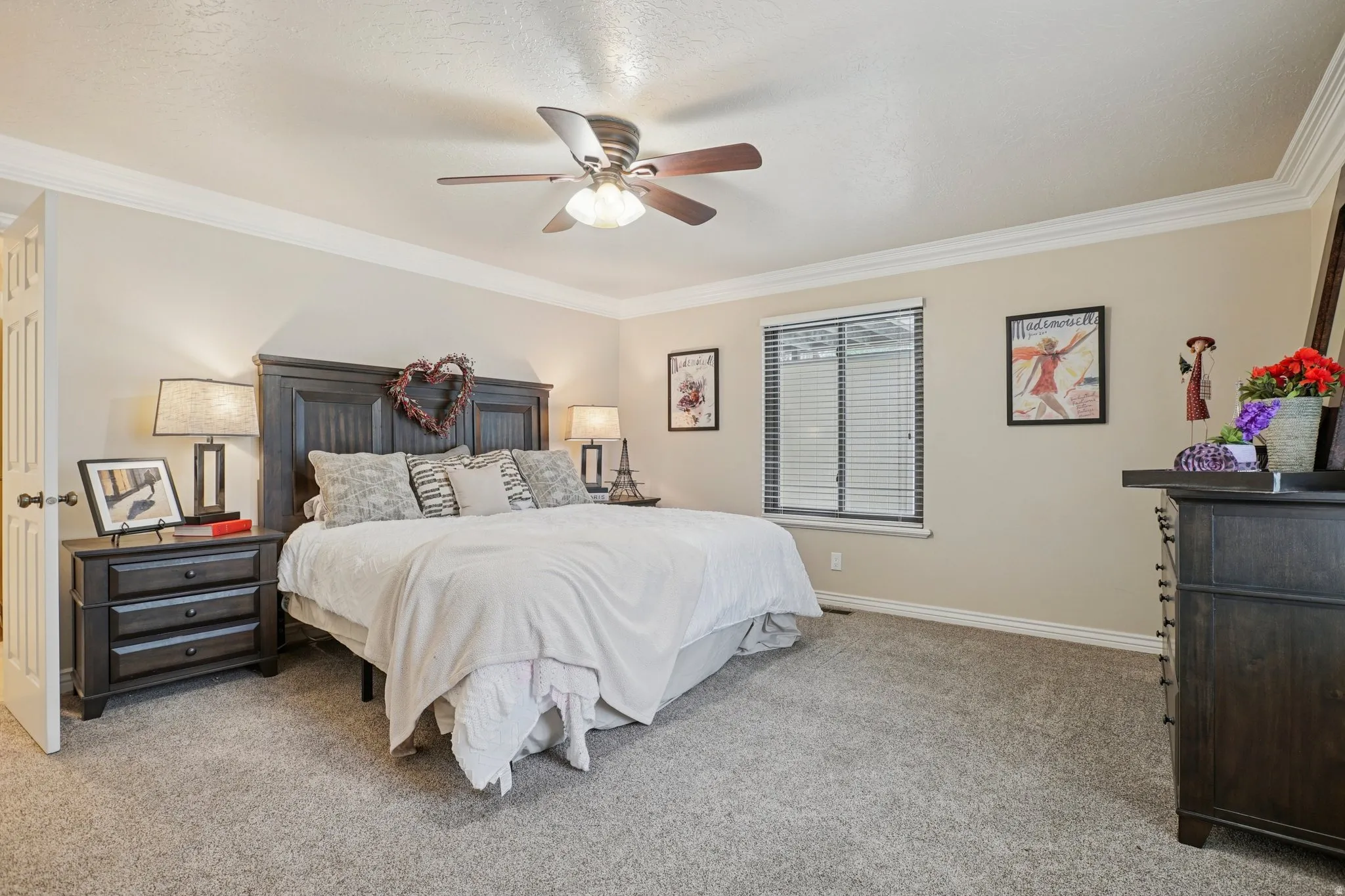 Bedroom featuring crown molding, light colored carpet, and a ceiling fan