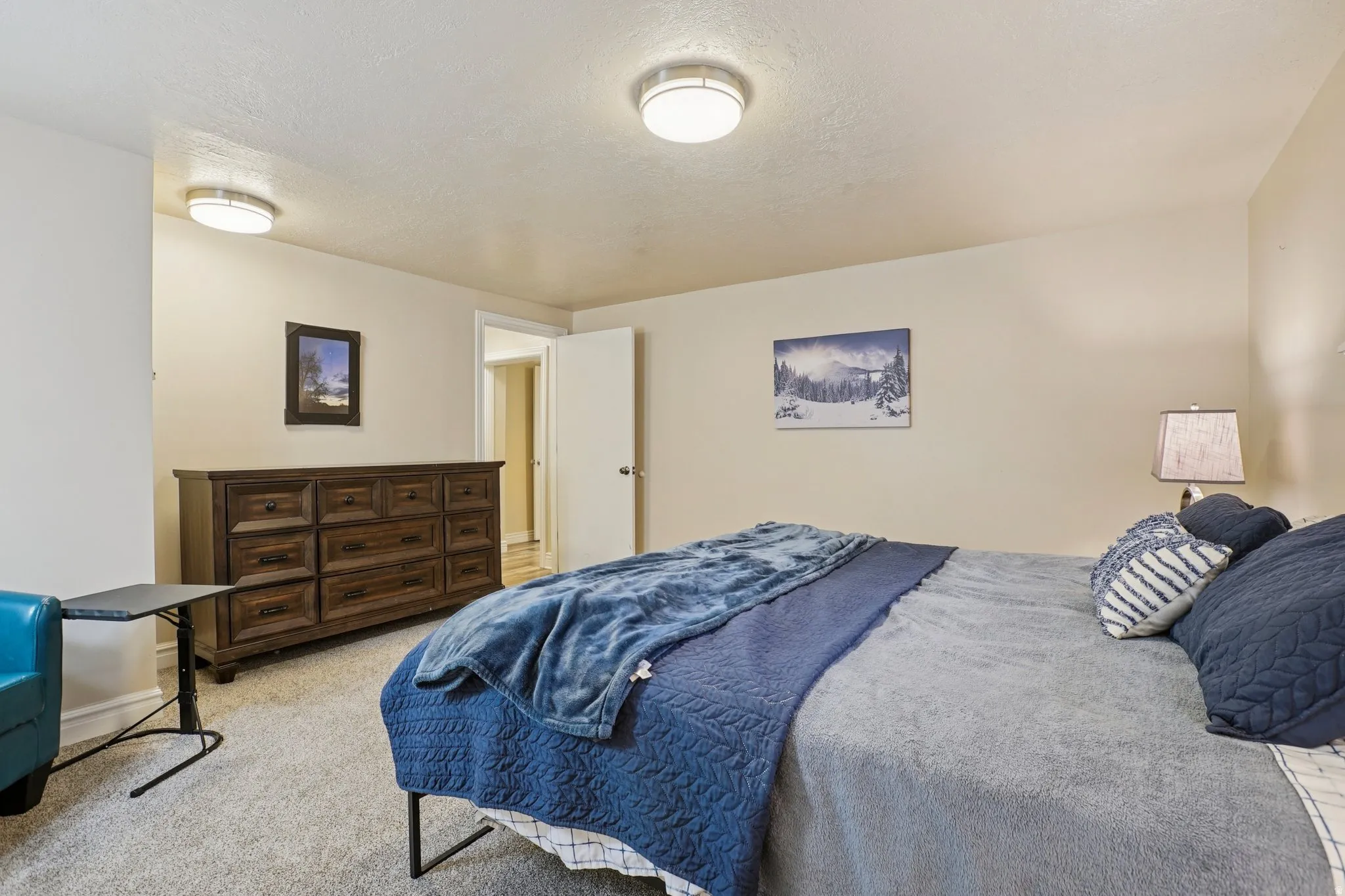 Bedroom featuring light colored carpet and a textured ceiling