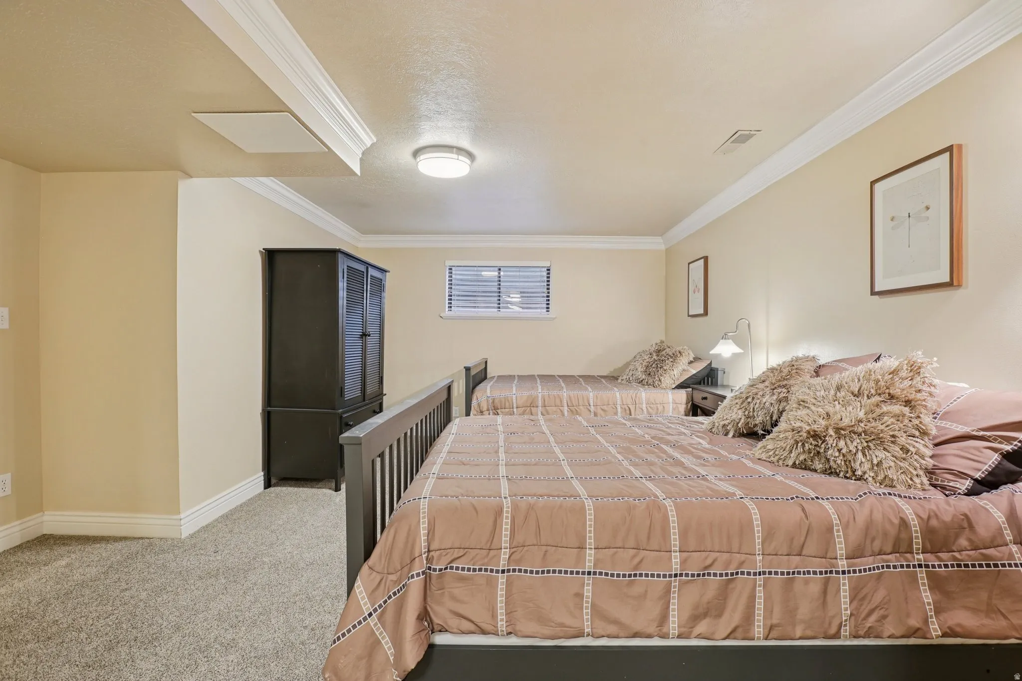 Bedroom featuring crown molding and light carpet