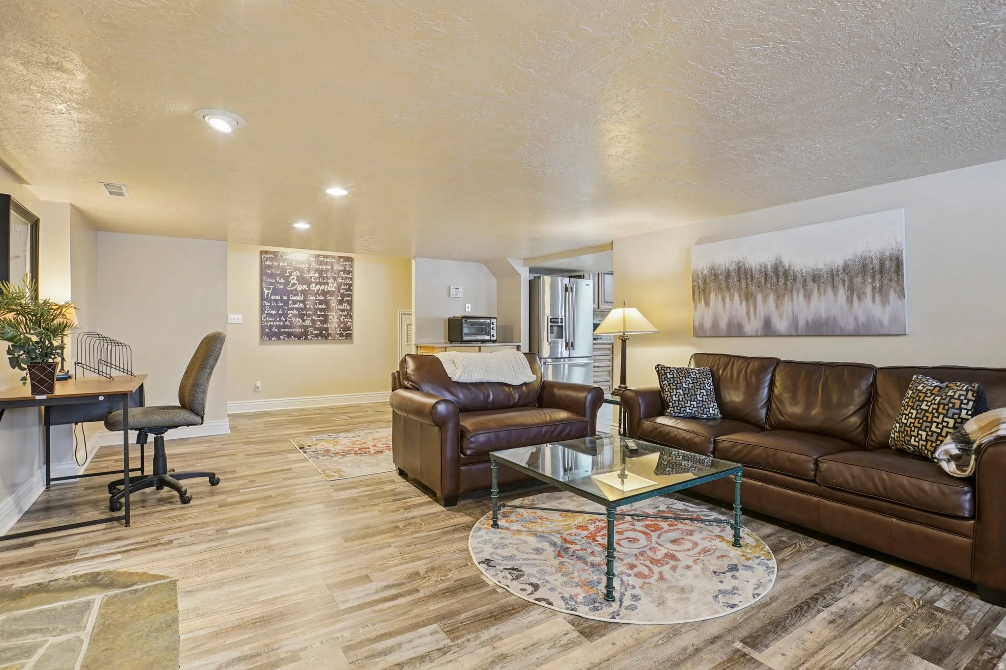 Living area featuring a textured ceiling, light wood-type flooring, and recessed lighting