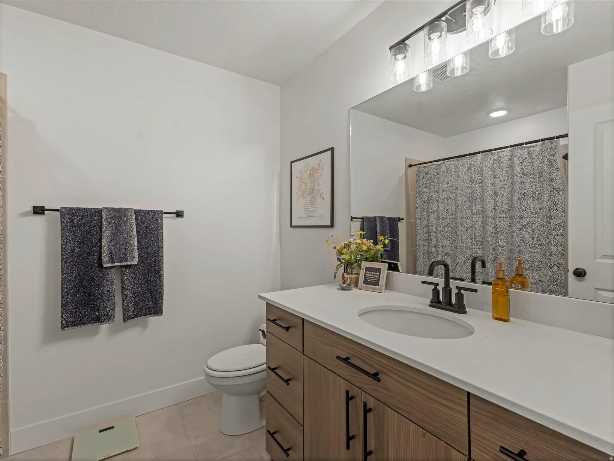 Bathroom with vanity, a shower with shower curtain, and light tile patterned floors