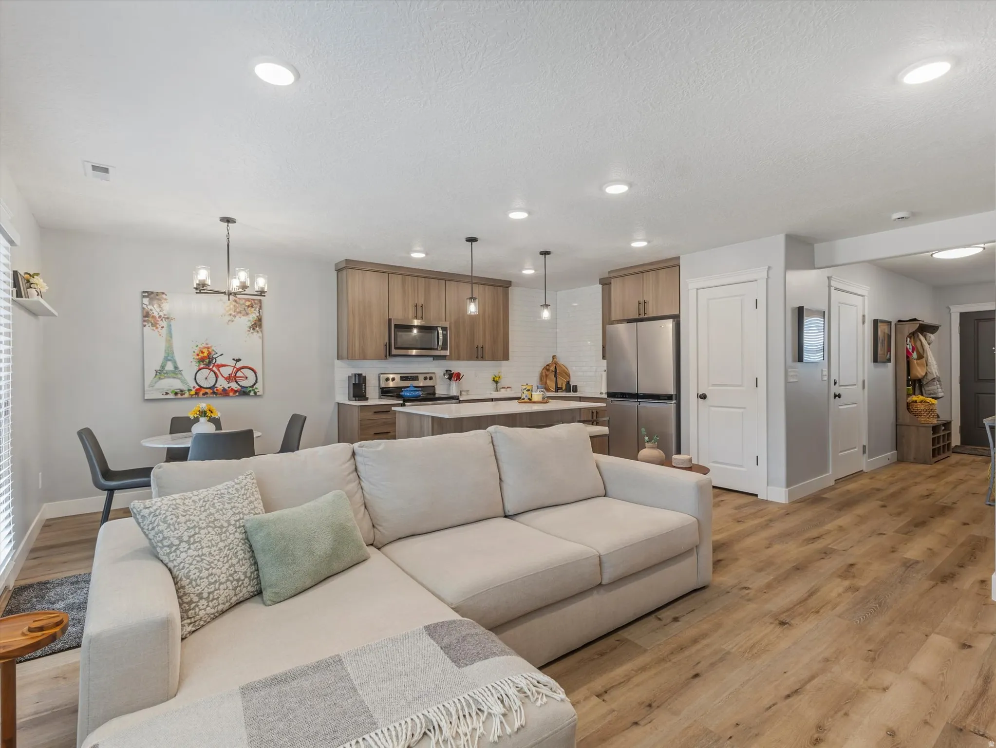 Living area featuring light wood-style flooring and hanging lights