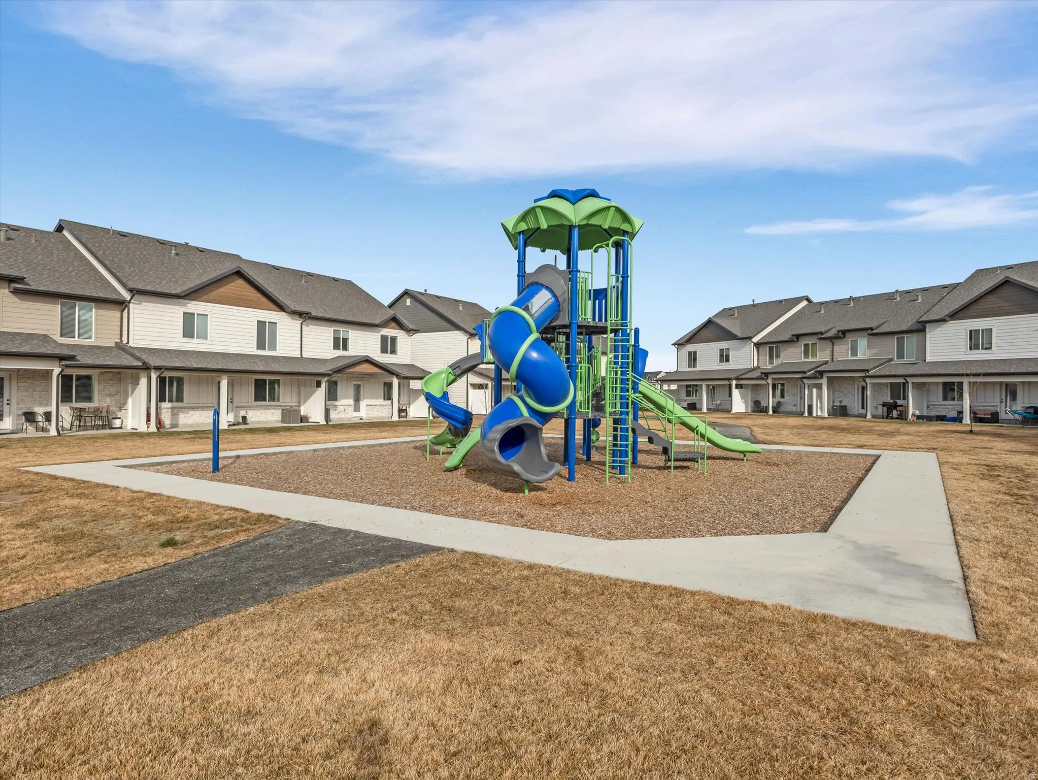 Communal playground featuring a residential view and a lawn