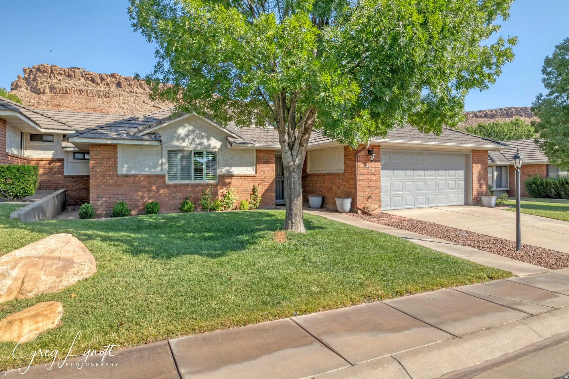 Ranch-style house with brick siding, concrete driveway, a front lawn, and a garage