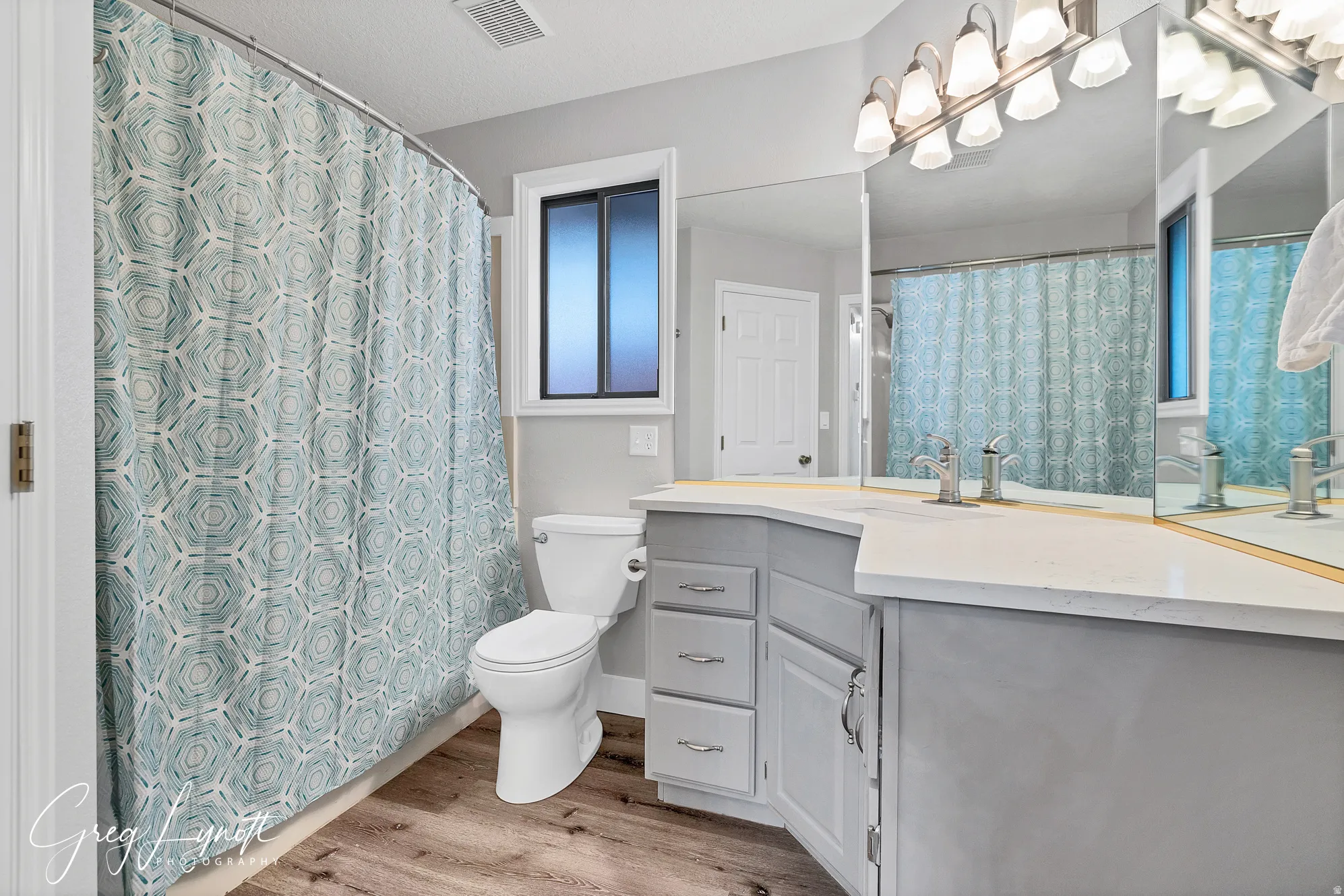 Full bathroom with vanity, a shower with curtain, and light wood-style flooring