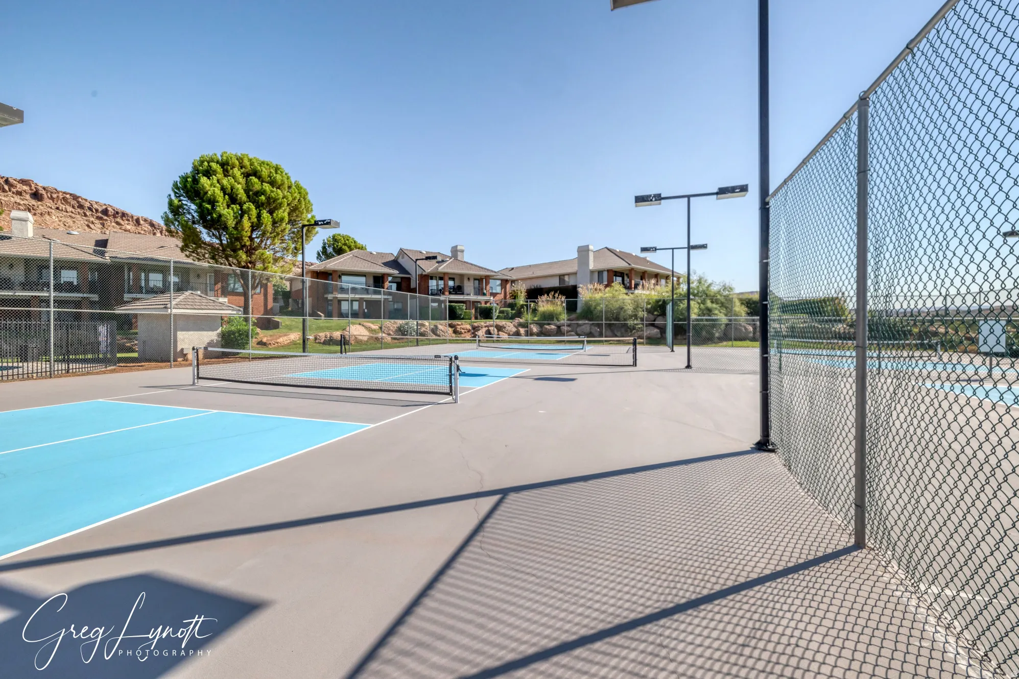 View of tennis court with a residential view
