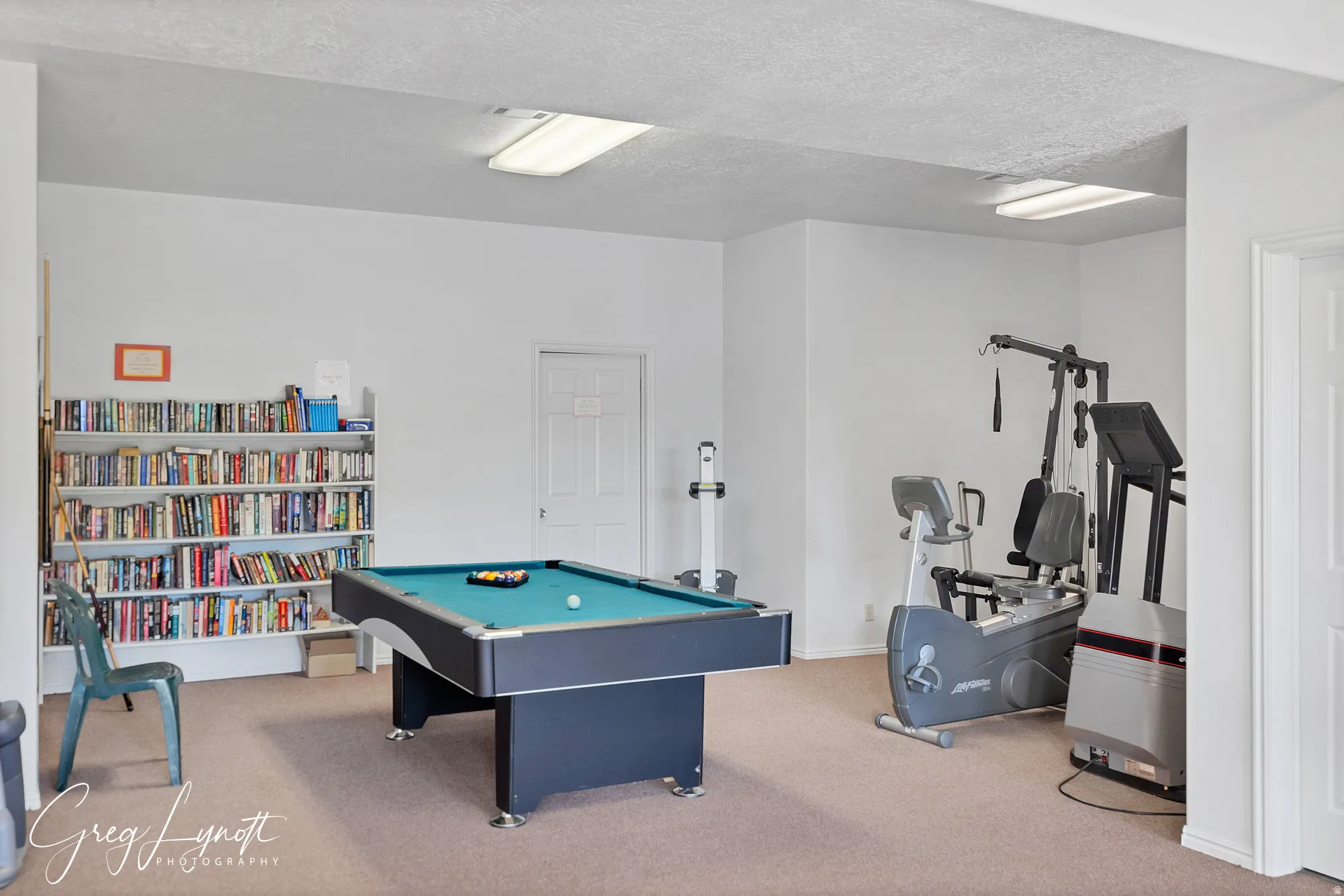 Rec room with billiards, light carpet, and a textured ceiling