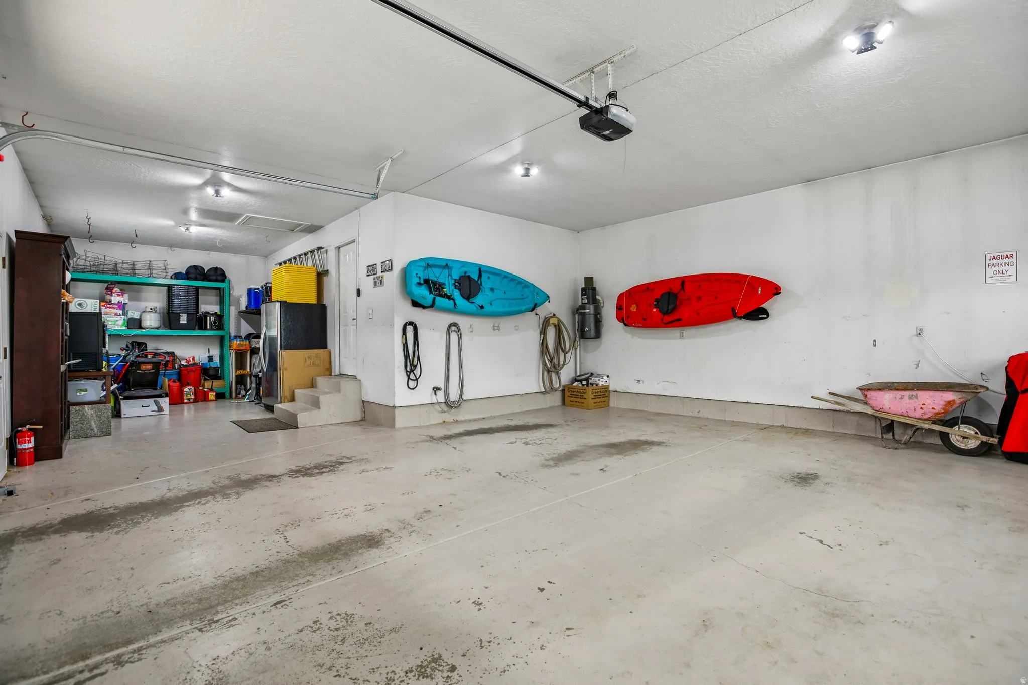 Garage with freestanding refrigerator and a garage door opener