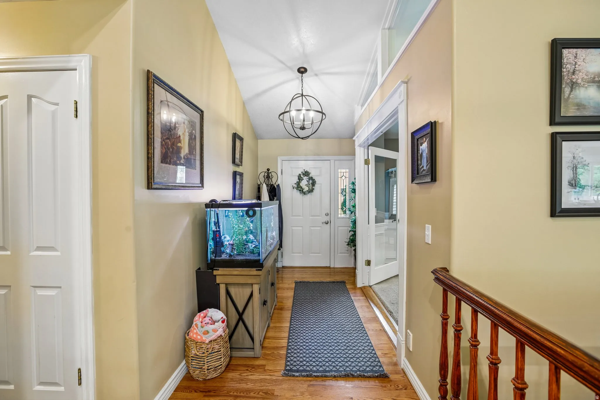 Entryway featuring wood finished floors, hanging lights, and vaulted ceiling