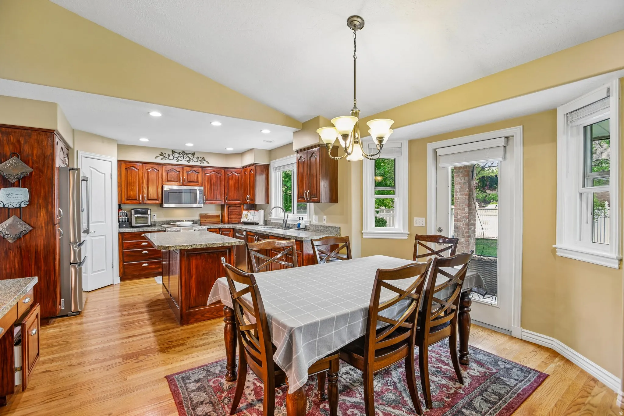 Dining space featuring lofted ceiling, suspended lighting, and light wood finished floors