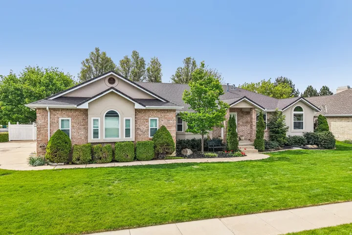 Single story home with brick siding, stucco siding, and roof with shingles