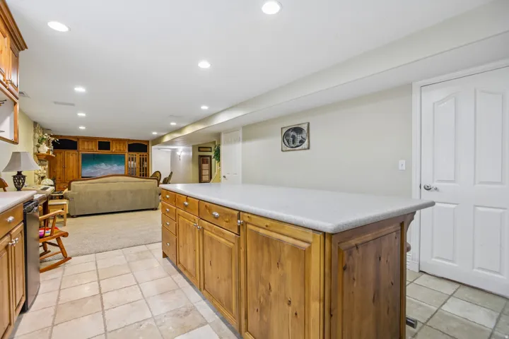 Kitchen featuring light countertops, recessed lighting, wood finish cabinetry, a center island, and open floor plan