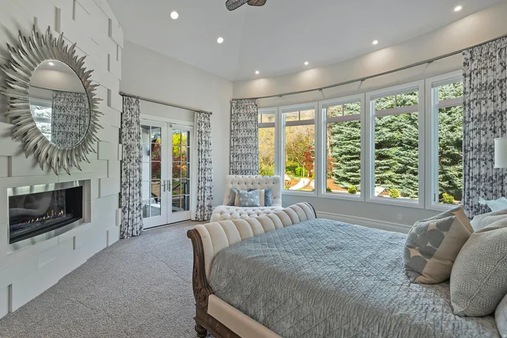 Carpeted bedroom with french doors, access to outside, a glass covered fireplace, and recessed lighting