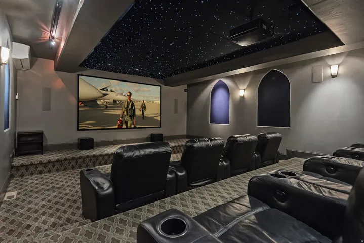 Carpeted home theater room with a mini split for heating / cooling and baseboards