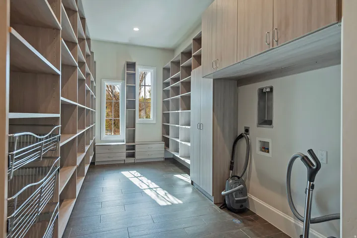 Walk in closet with dark wood-style floors