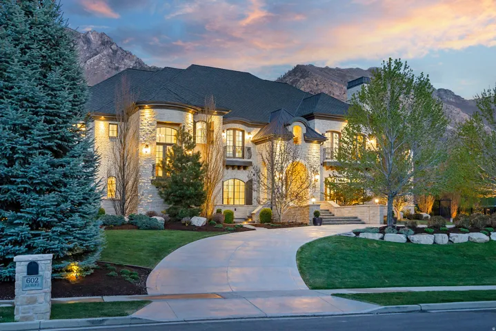 French provincial home with stone siding, a yard, a balcony, and a mountain view