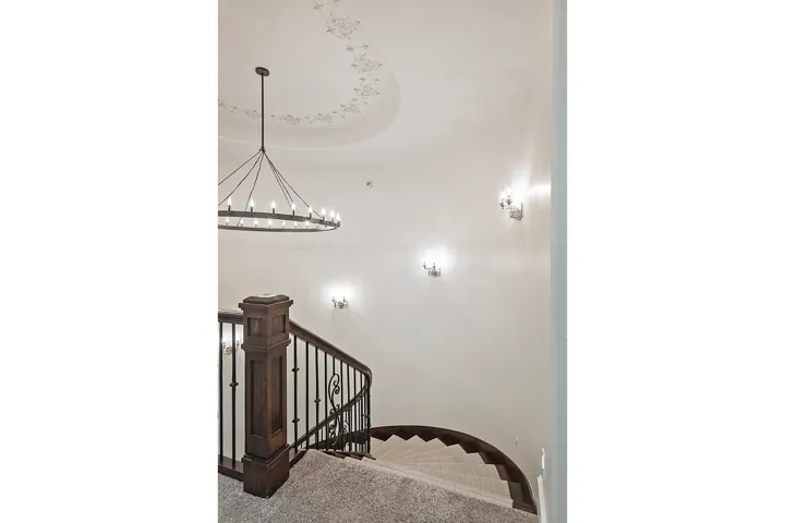 Stairway with carpet flooring, a chandelier, and a raised ceiling