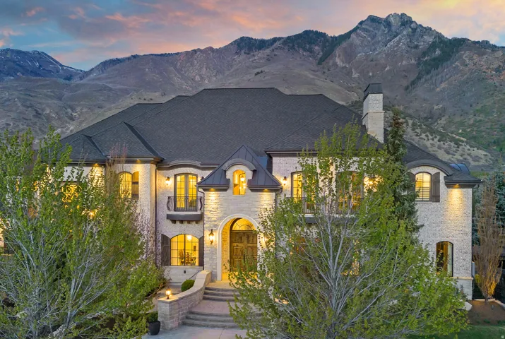 French provincial home with a chimney, a mountain view, and brick siding