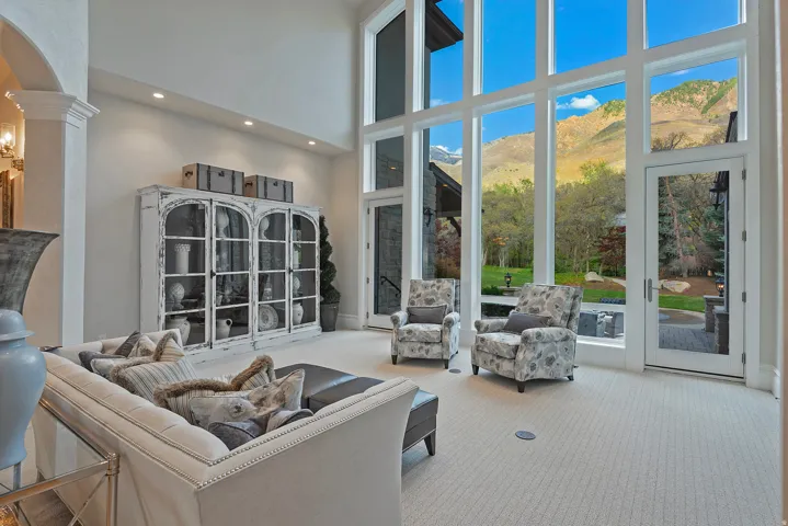 Living room with a mountain view, a high ceiling, carpet, arched walkways, and recessed lighting