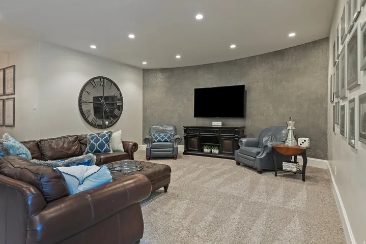 Carpeted living room with recessed lighting and baseboards