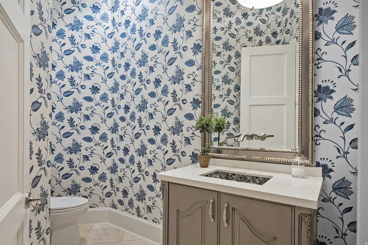 Half bath featuring wallpapered walls, vanity, and light tile patterned floors