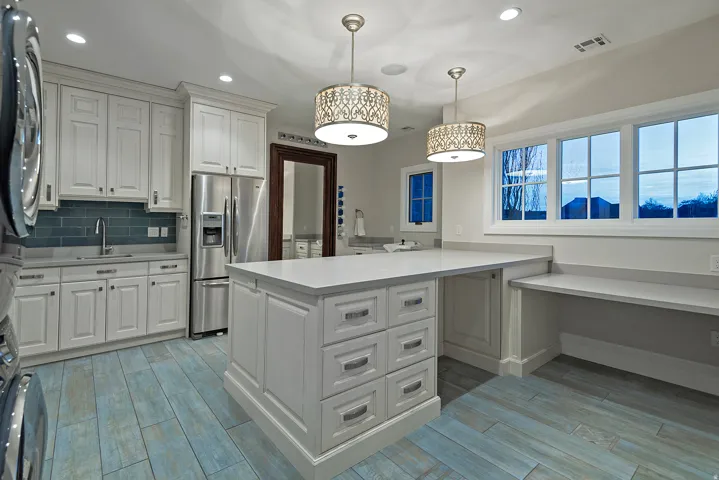 Kitchen featuring wood tiled floors, stainless steel refrigerator with ice dispenser, light countertops, and washer / clothes dryer
