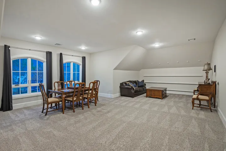 Dining area featuring light carpet and vaulted ceiling