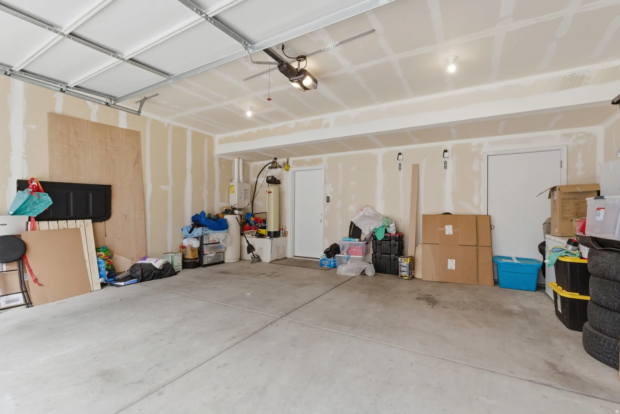 Garage featuring water heater and a garage door opener