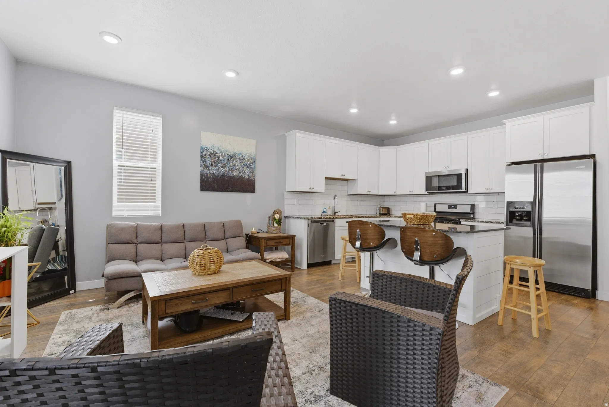 Living room with light wood-type flooring and recessed lighting