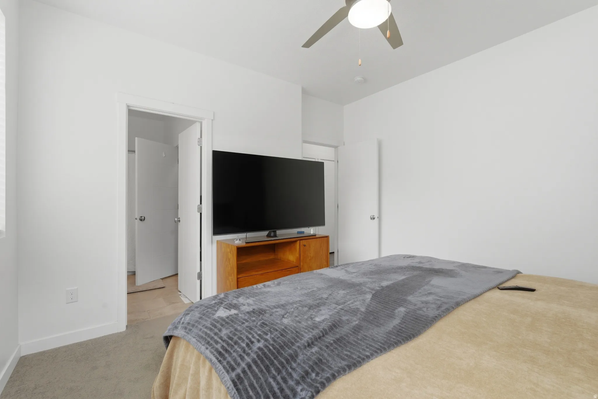Bedroom featuring light carpet and a ceiling fan