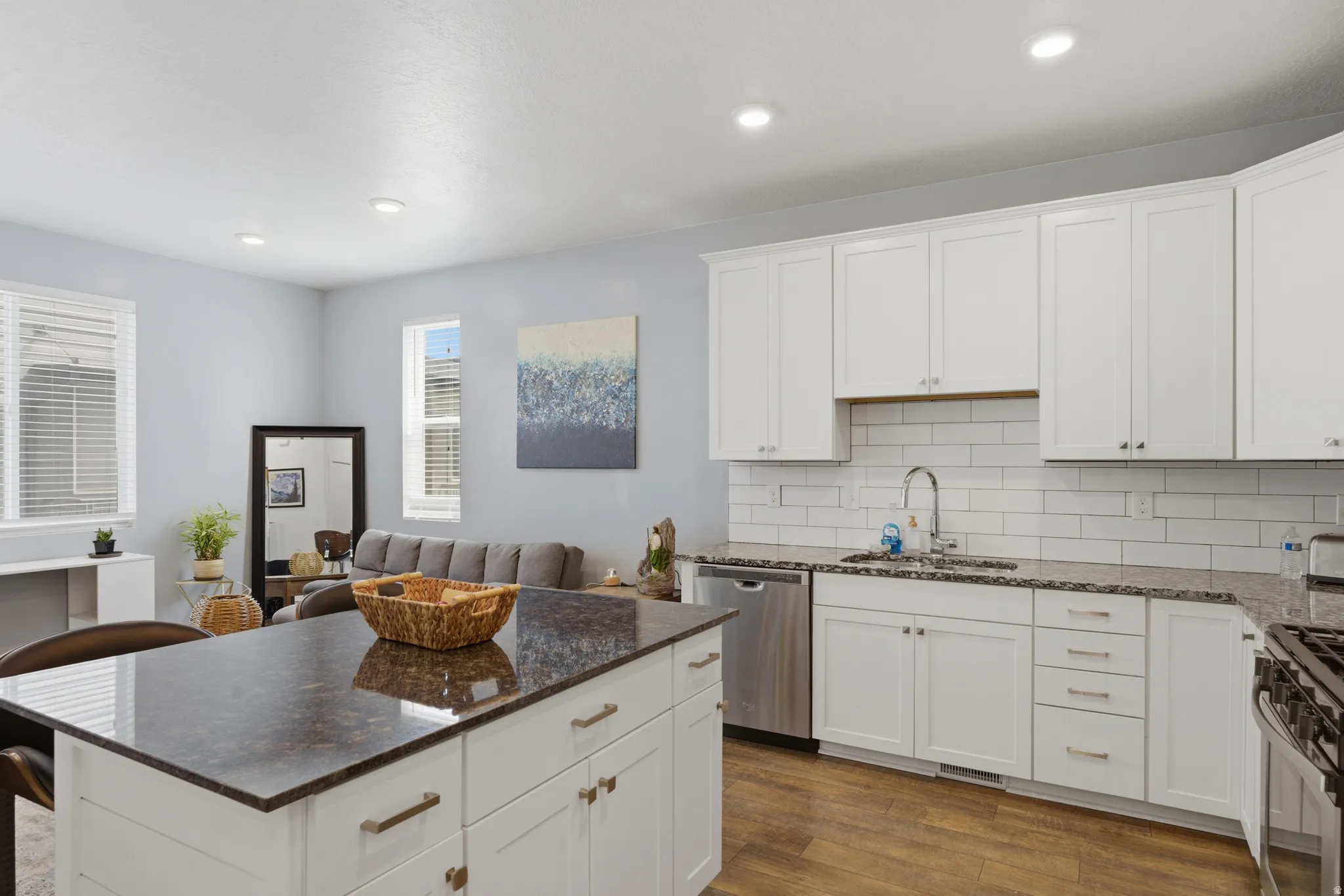 Kitchen featuring a center island, dark stone counters, white cabinetry, dark wood-style floors, and stainless steel appliances