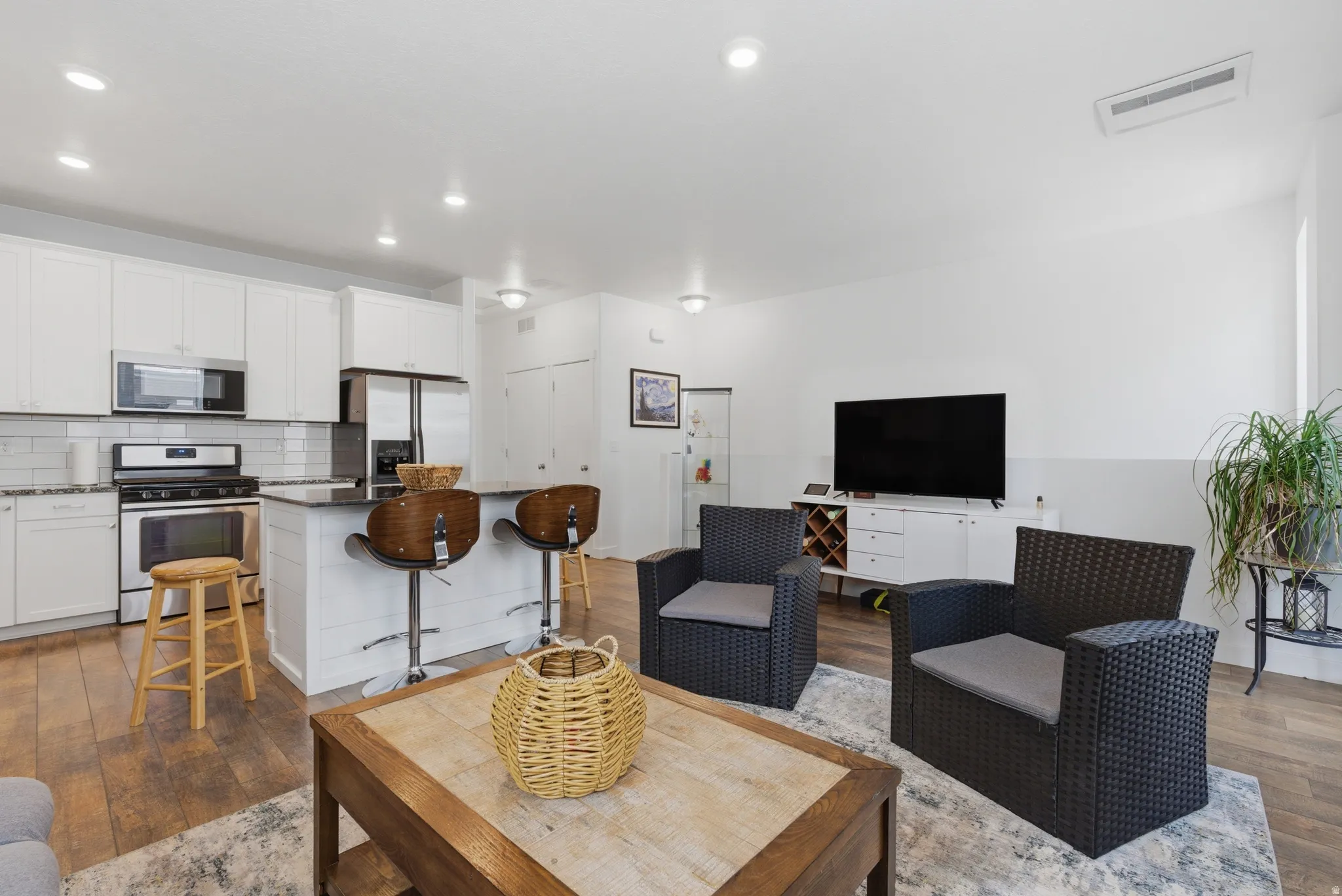Living area with hardwood / wood-style flooring and recessed lighting