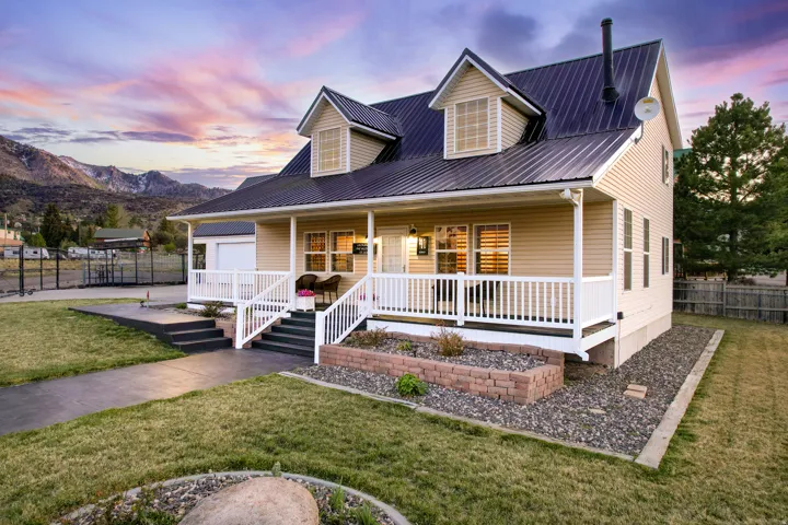 View of front facade with covered porch, a metal roof, a 2 car garage, and a mountain view