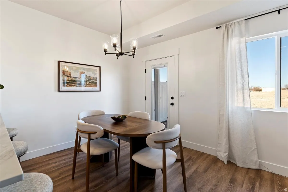 Dining space featuring dark wood-style flooring and hanging lights
