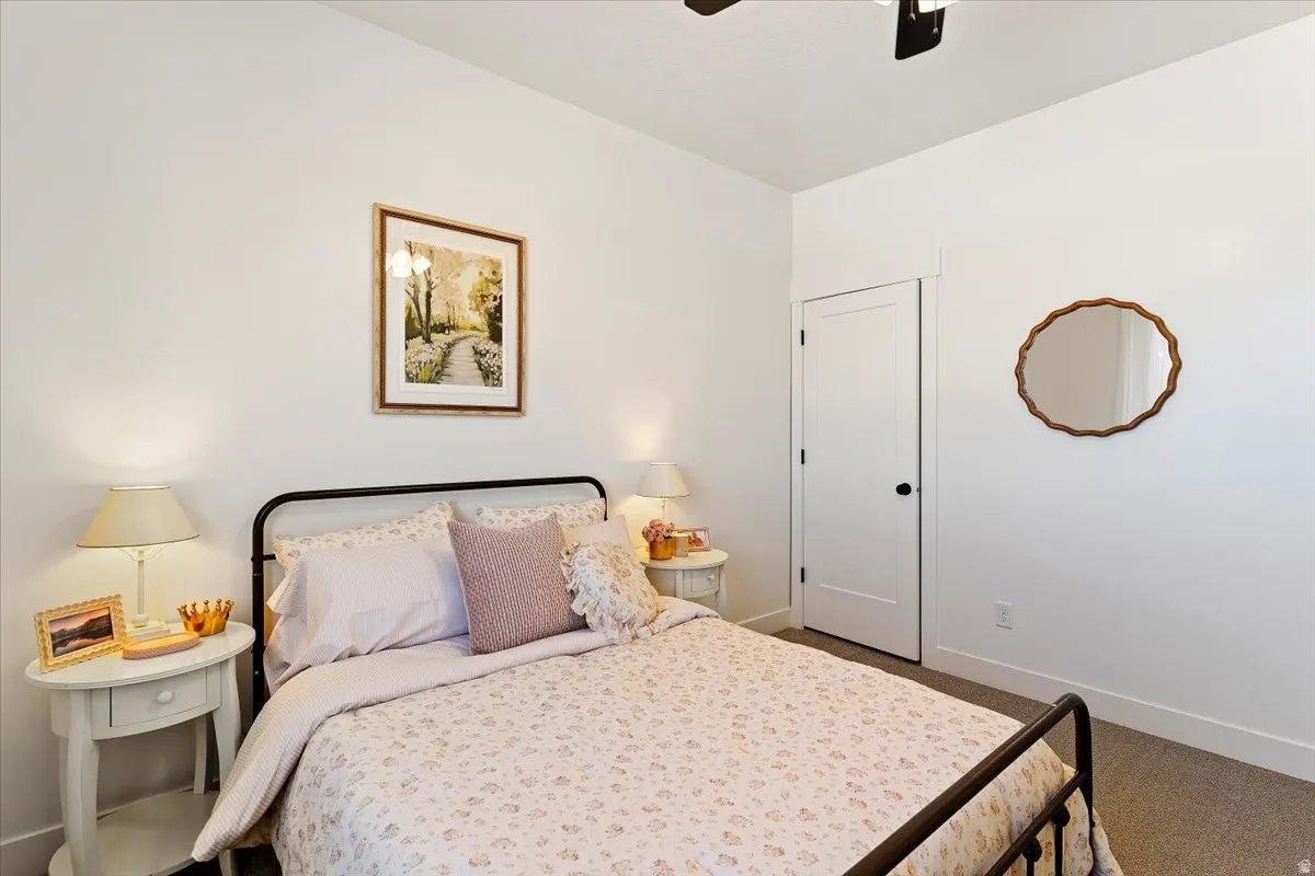 Bedroom featuring dark carpet and a ceiling fan