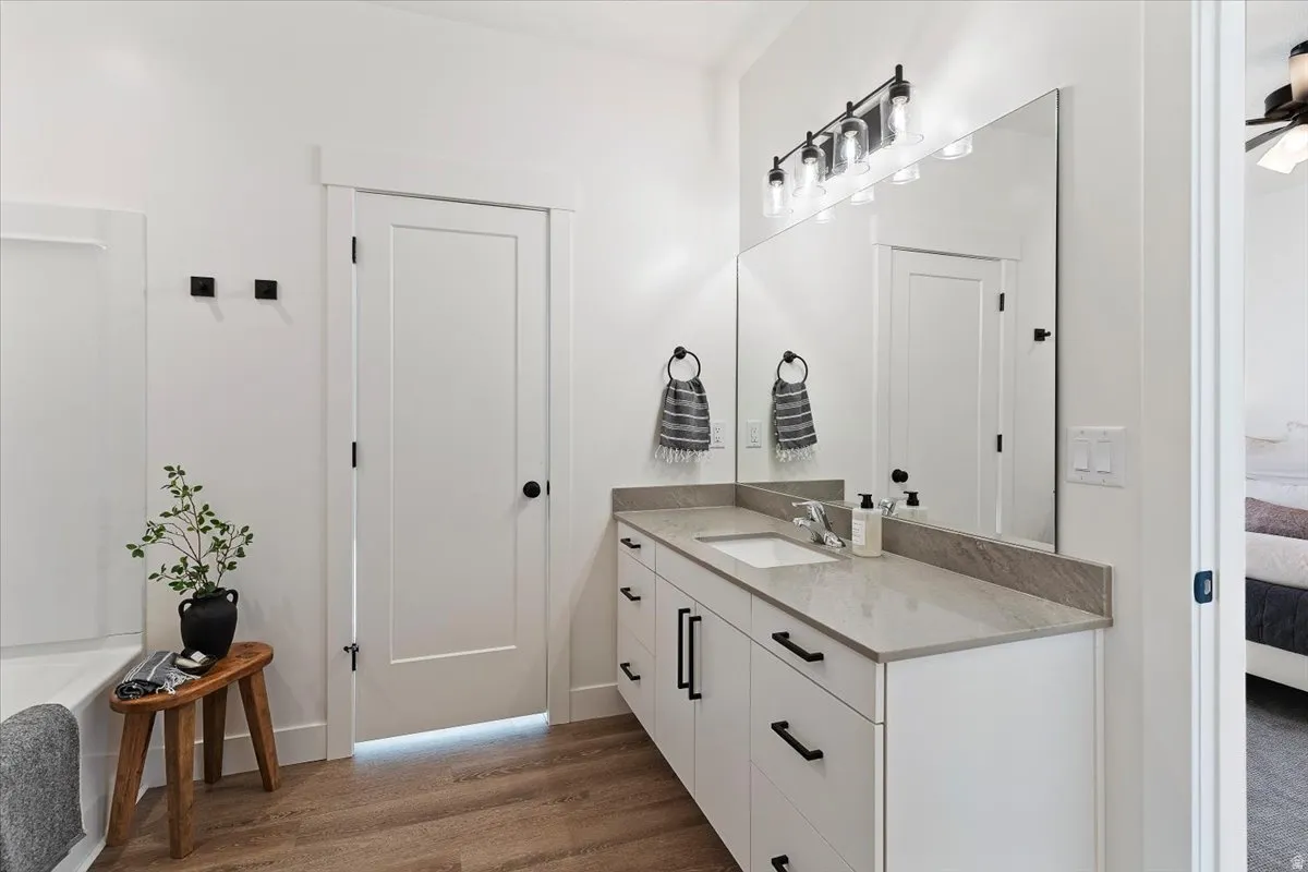 Full bath featuring ensuite bath, vanity, dark wood-style flooring, and a garden tub