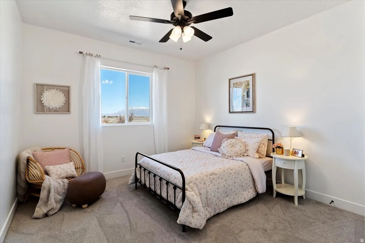 Carpeted bedroom featuring baseboards and ceiling fan