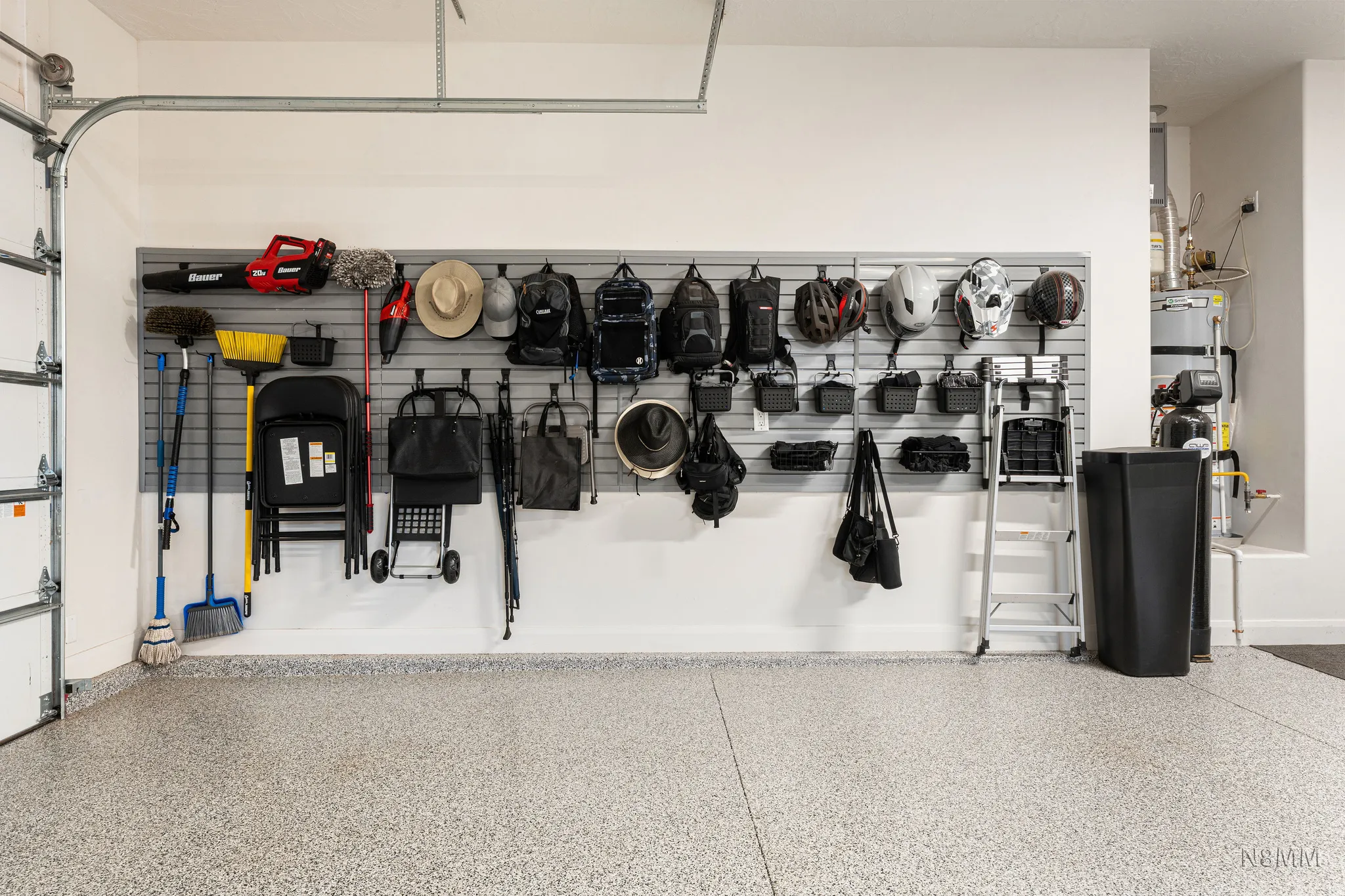 Garage featuring water heater and baseboards