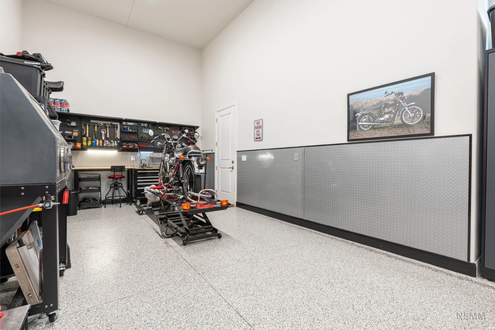Miscellaneous room featuring a high ceiling and dark aggregate flooring