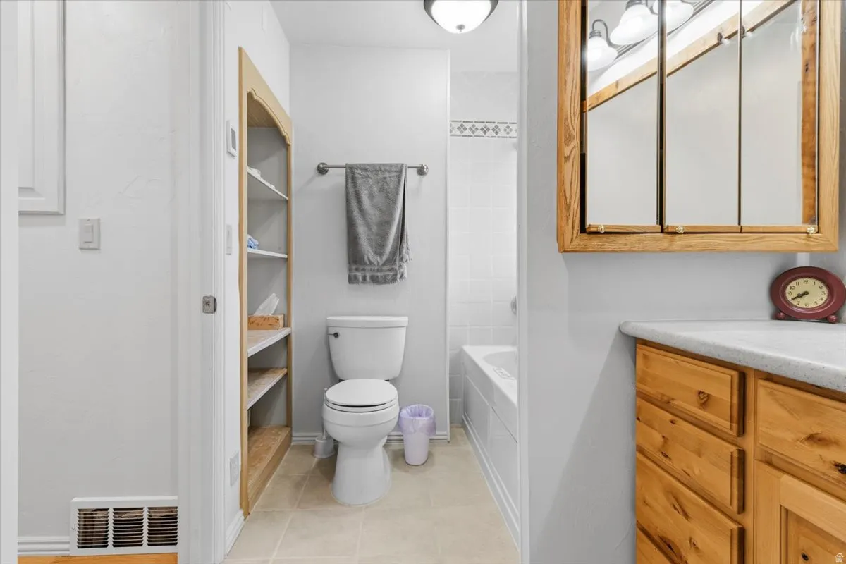 Full bathroom featuring vanity, bathtub / shower combination, and light tile patterned floors
