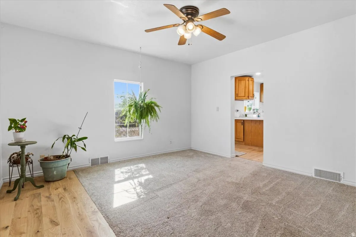 Spare room with plenty of natural light, a ceiling fan, and light wood-style floors