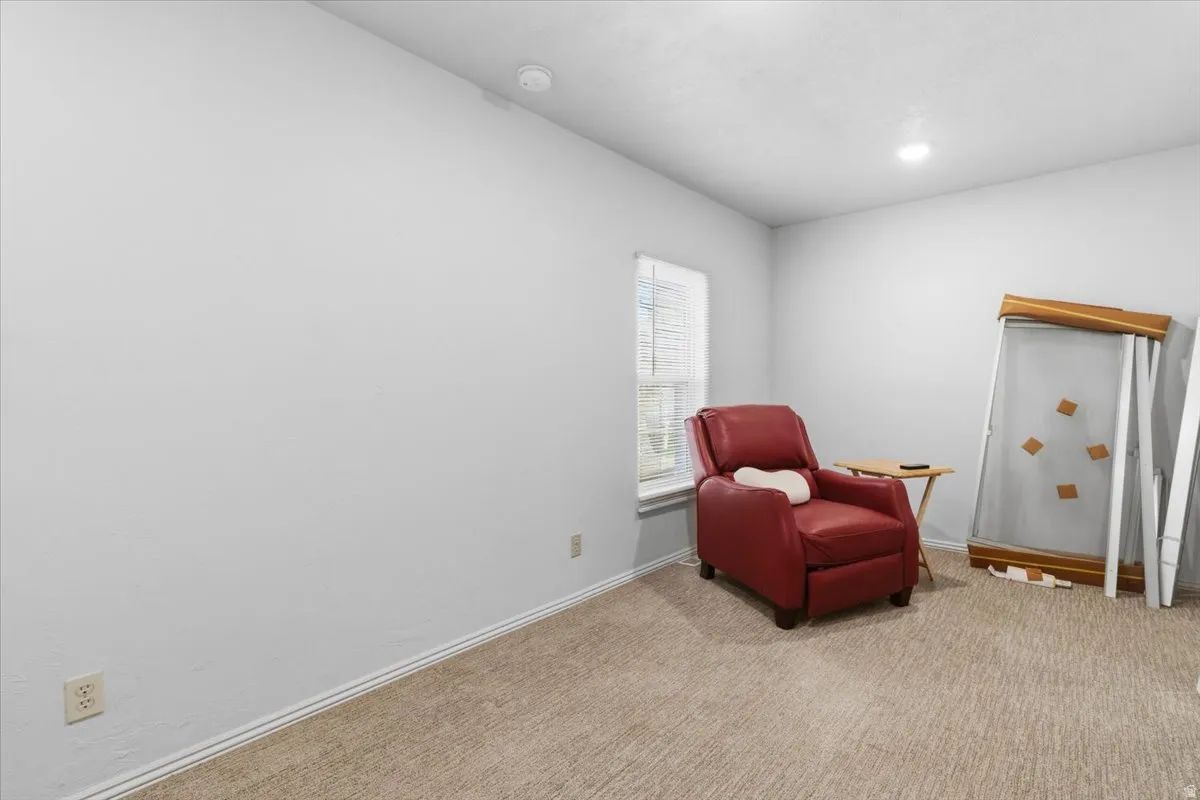Sitting room featuring light carpet and vaulted ceiling
