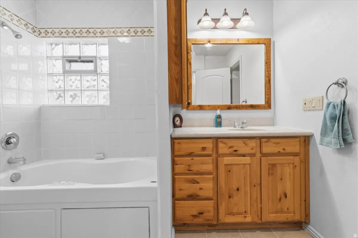 Full bathroom featuring vanity, shower / bath combination, and light tile patterned floors