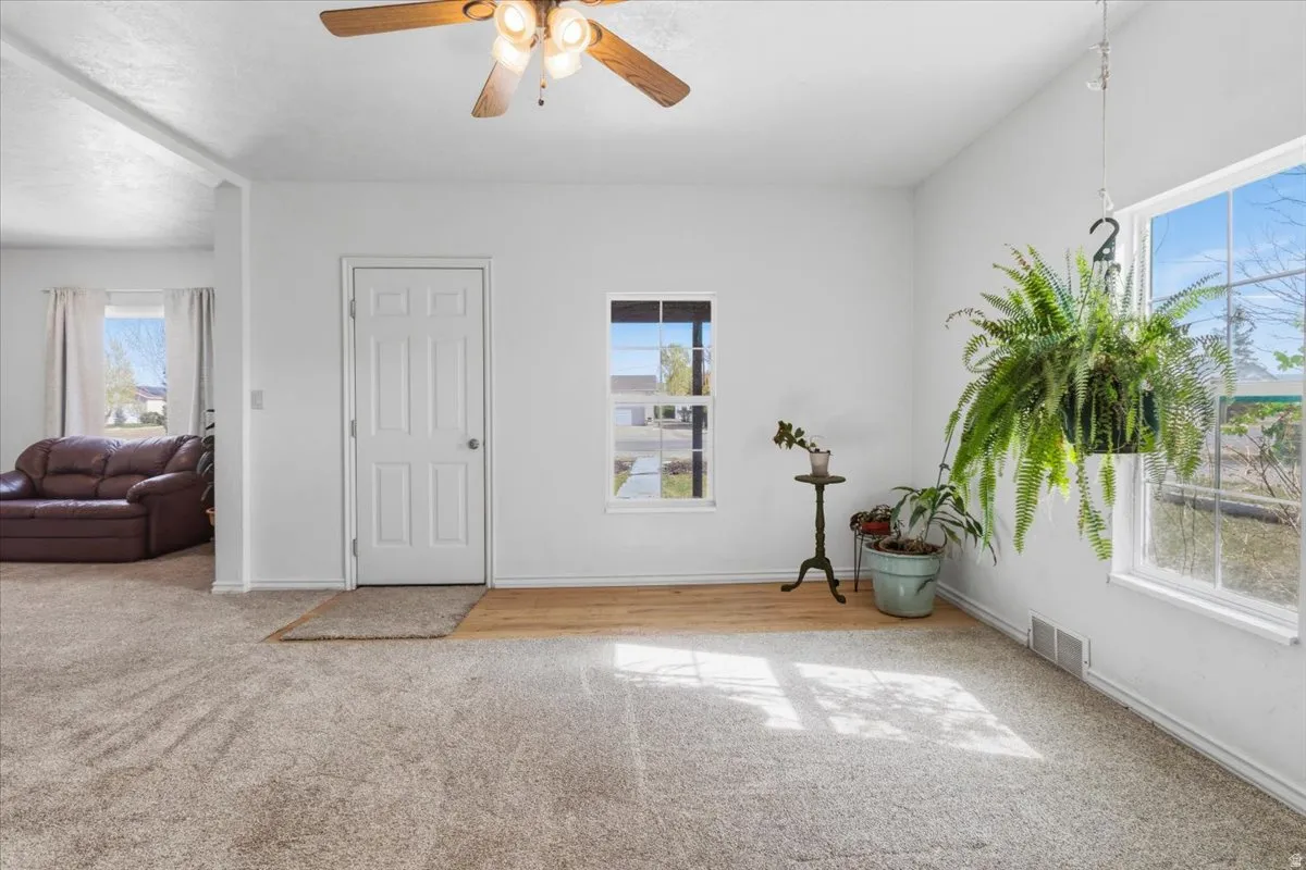 Entryway featuring light carpet and a ceiling fan