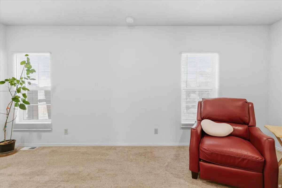 Living area featuring carpet flooring and baseboards